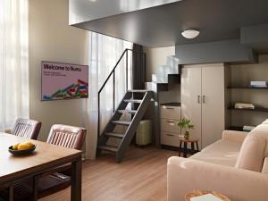 a living room with a staircase and a couch at YAYS Amsterdam Maritime by Numa in Amsterdam