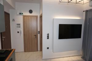 a living room with a flat screen tv on a wall at The Little House Lamia - Fresh Central Apartment in Lamía