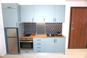 a kitchen with blue cabinets and a stove at The Little House Lamia - Fresh Central Apartment in Lamía