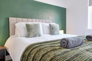 a bedroom with a large bed with a green wall at Colchester 4BR Home, Sleeps 8, Fast WiFi, Perfect for Contractors in Hythe