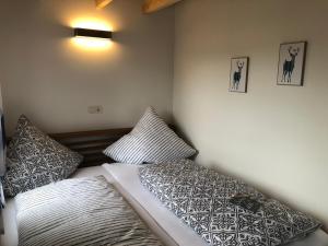 a bedroom with a bed and two pillows on it at Ferienhaus am Jakobsberg in Königsfeld +4 photos