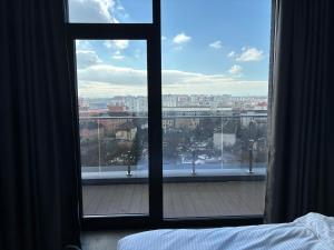 a bedroom with a view of a city from a window at Bavaro apartments 3 in Ivano-Frankivsk