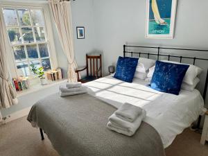 a bedroom with a large bed with towels on it at The Old Bakehouse in Colyton