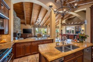 a large kitchen with wooden cabinets and a large island at Villa Merion at PGA West | Grand Tuscan Estate in La Quinta