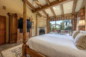 a bedroom with a bed with a fireplace and a television at Villa Merion at PGA West | Grand Tuscan Estate in La Quinta +112 photos