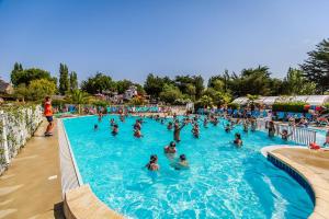 a group of people in a swimming pool at a resort at Le Logis du Manoir in Sarzeau