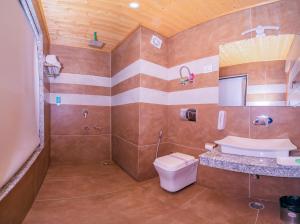 a bathroom with a toilet and a sink at Snow City's Montana Blues Resort Manali - Heated & Air-Cooled Stay in Manāli +71 photos