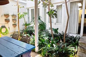 a porch with a blue table and some plants at Hornbill House Self Catering Accommodation in Hermanus
