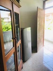 an open door to a room with a refrigerator at Sun Shine House in Matara