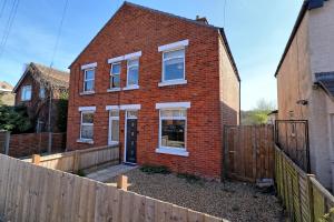 a brick house with a fence in front of it at Colchester 4BR Home, Sleeps 8, Fast WiFi, Perfect for Contractors in Hythe