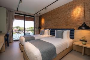 a bedroom with two beds and a brick wall at Aloha Tropicana Samui in Chaweng +131 photos