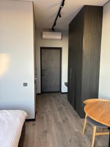 a room with a bed and a table and a door at Bavaro apartments 3 in Ivano-Frankivsk