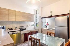a kitchen with a glass table and a stainless steel refrigerator at "Venetian Elegance Villa" - near Venice historic center in Mira