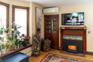 a living room with a fireplace and a television at Forest City Oasis and Spa in South Portland