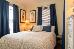 a bedroom with a white bed and blue curtains at Forest City Oasis and Spa in South Portland