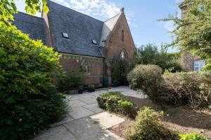 an old brick church with a pathway in front of it at Church conversion, Private garden, Parking in Cuckfield