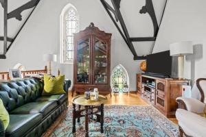 a living room with a couch and a table at Church conversion, Private garden, Parking in Cuckfield