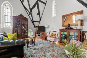 a living room with a couch and a mirror at Church conversion, Private garden, Parking in Cuckfield