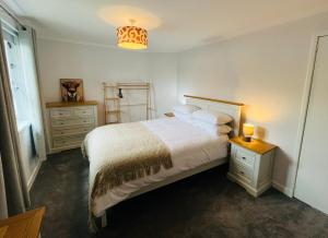 a bedroom with a bed and a lamp on a table at Inas Place in Caol