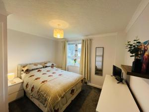 a bedroom with a bed and a desk with a computer at Inas Place in Caol