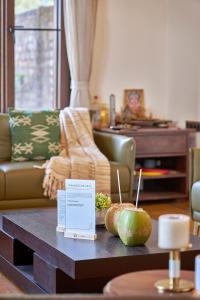 a living room with a table with fruits on it at SaffronStays The Devrai by the Sea in Bhogwe
