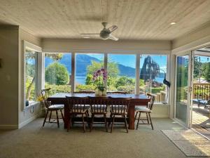 a dining room with a table and chairs and a large window at Captain Cottage in Bowen Island