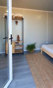 a room with a bedroom with a bed and a mirror at Free People Bungalow & Cort in Vama Veche