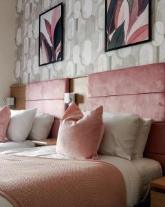 a bedroom with a bed with pink and white pillows at Mina Hotel by PLI in London