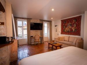 a living room with a bed and a couch at Les Remparts Hôtels et Demeures Historiques in Beaune