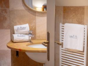 a bathroom with a sink and a mirror and towels at Les Remparts Hôtels et Demeures Historiques in Beaune +128 photos