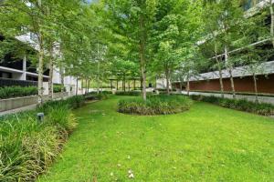 a yard with trees and grass and a building at Modern 1BR Views in Belconnen in Belconnen