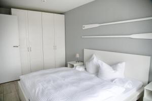 a white bedroom with a white bed with white pillows at Lagunenstadt am Haff - Fewo 093 Ree! in Ueckermünde