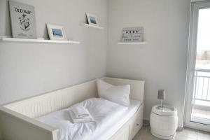 a white bed in a room with a window at Lagunenstadt am Haff - Fewo 093 Ree! in Ueckermünde