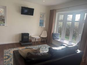 a living room with a couch and a table and window at Stylish Holiday Home - Caherdaniel in Caherdaniel