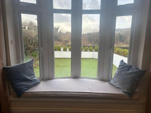 a window seat with two pillows in front of a window at Stylish Holiday Home - Caherdaniel in Caherdaniel +3 photos