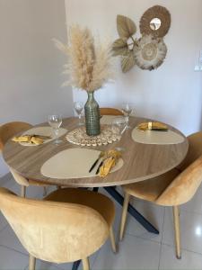 a wooden table with glasses and a vase with flowers on it at Apartamento céntrico junto paseo, playas y zonas de interés!! in Águilas