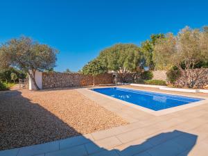 a swimming pool in a yard with a fence and trees at Can Borras by 3VILLAS in Llumesanas