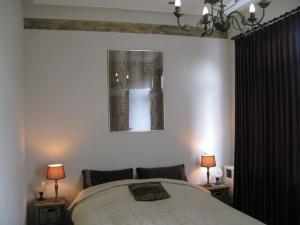 ein Schlafzimmer mit einem Bett mit zwei Lampen und einem Bild in der Unterkunft Pension Zee en Duinzicht in Zandvoort