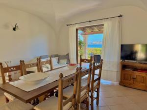a dining room with a table and a television at Villa Rosa in Cannigione
