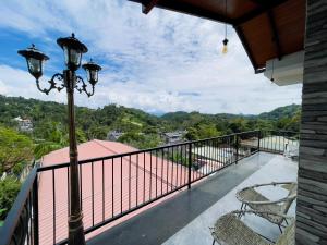 a balcony with chairs and a street light and a view at Mulberry villa in Kandy