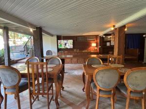 a dining room with wooden tables and chairs at Jardim da Amazônia Lodge in Sao Jose do Rio Claro