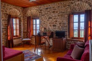 a living room with a brick wall at xenonas ton xromaton - Guest house of colors in Lafkos