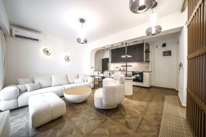 a living room with a couch and chairs and a kitchen at Allegro Suites in Rethymno