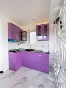 a kitchen with purple cabinets and a sink at Mulberry villa in Kandy