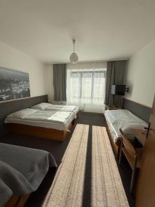 a bedroom with two beds and a window at Penzion Vis a Vis in Třebíč
