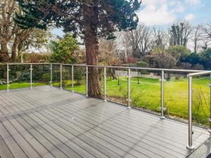 a wooden deck with a tree and a fence at Springvale in Cardross