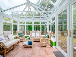 a conservatory with a glass roof and wicker furniture at Springvale in Cardross
