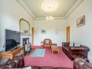 a living room with leather furniture and a flat screen tv at Springvale in Cardross