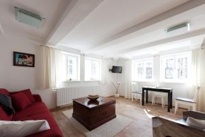 a living room with a red couch and a table at Schlaf-gut Appartments in Quedlinburg