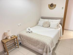 a white bedroom with a bed with shoes on it at Apartamento céntrico junto paseo, playas y zonas de interés!! in Águilas